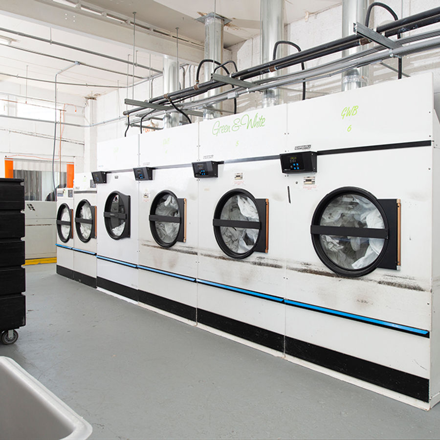 Team member operating laundry equipment